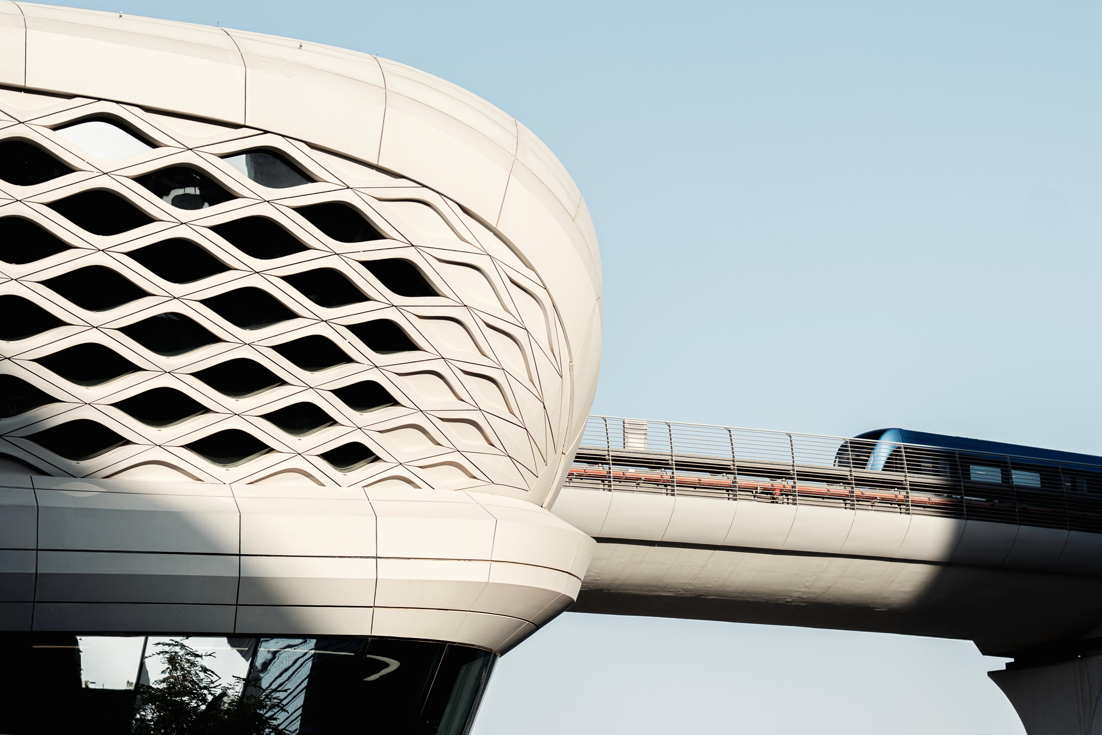 KAFD metro station in Riyadh: its latticed shell beside the elevated viaduct, with a train crossing