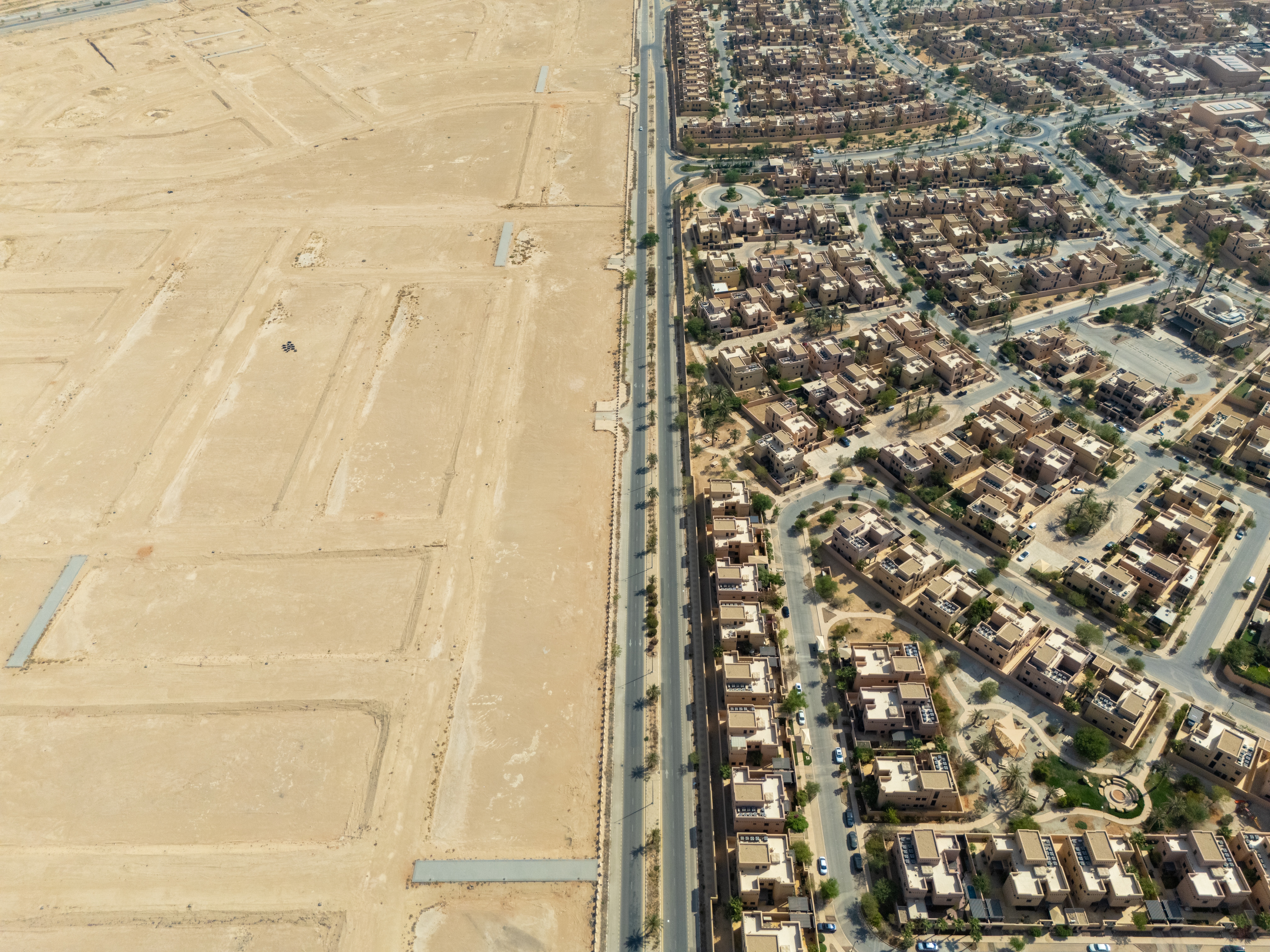 Aerial view of a residential district in Saudi Arabia meeting open desert along a single road